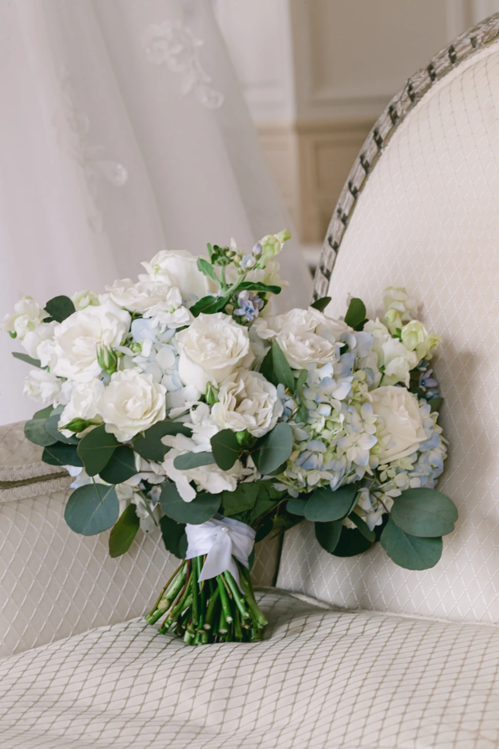 White rose and hydrangea bouquet resting on a chair
