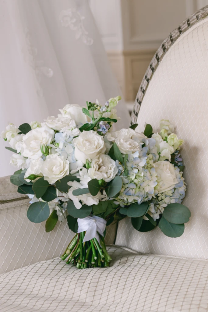 White rose and hydrangea bouquet resting on a chair