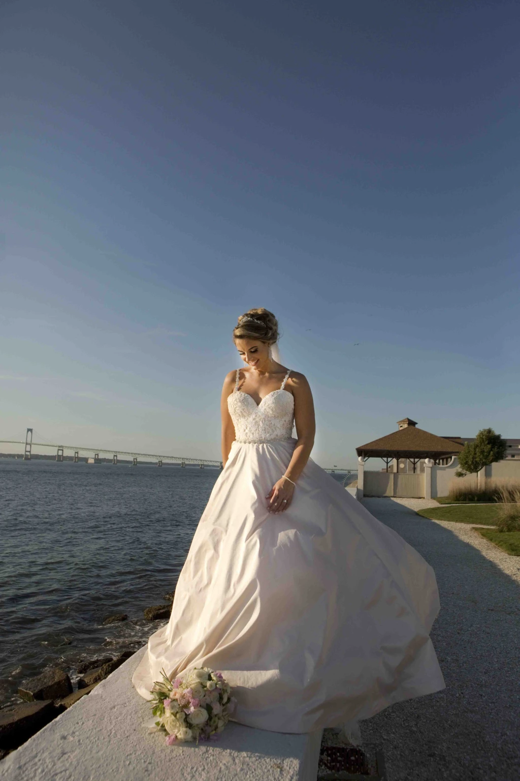 Bride in a ball gown on a waterfront walkway