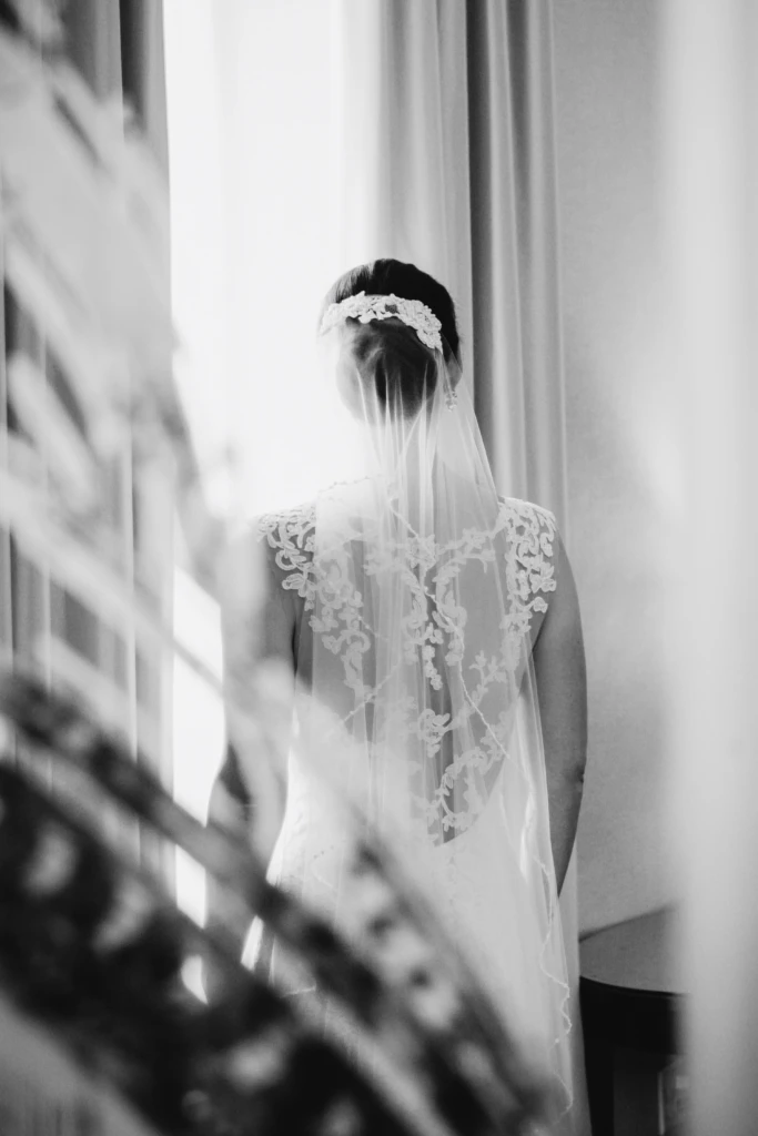 Black-and-white portrait of a bride's lace back and veil