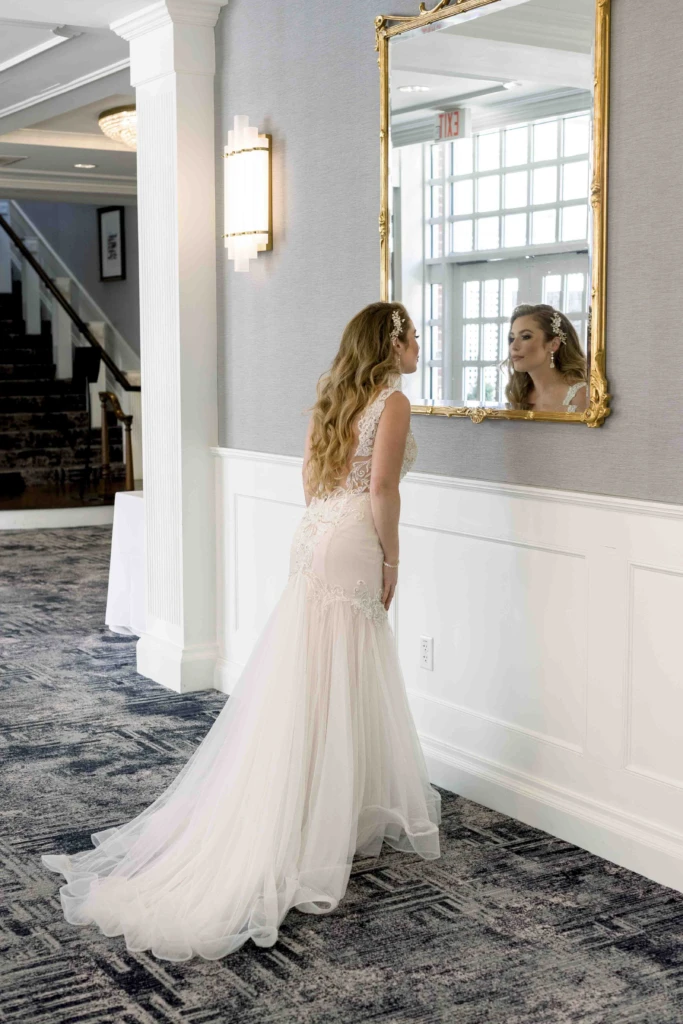 Bride looking into a gilded mirror